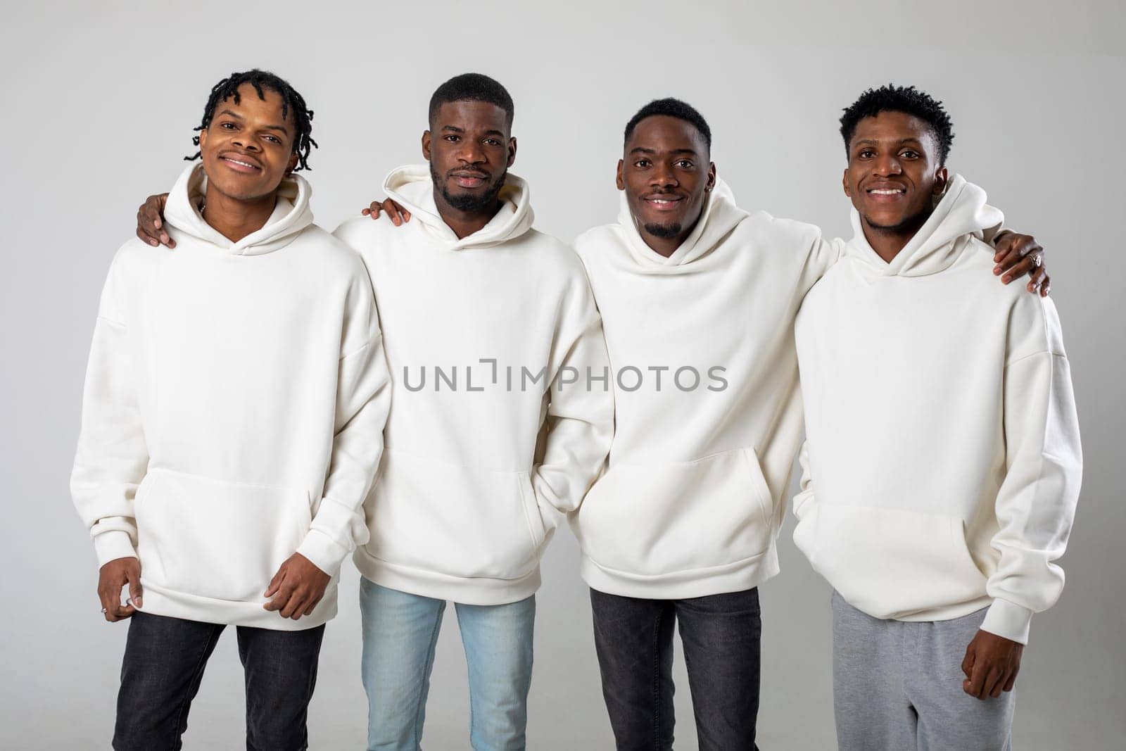 Group of African American guys in brown hoodies posing on a white background wearing sunglasses by Freeman_Studio