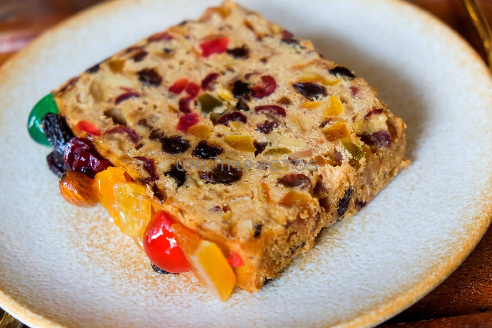 Fruit cake on a white plate, close-up, selective focus by ponsulak