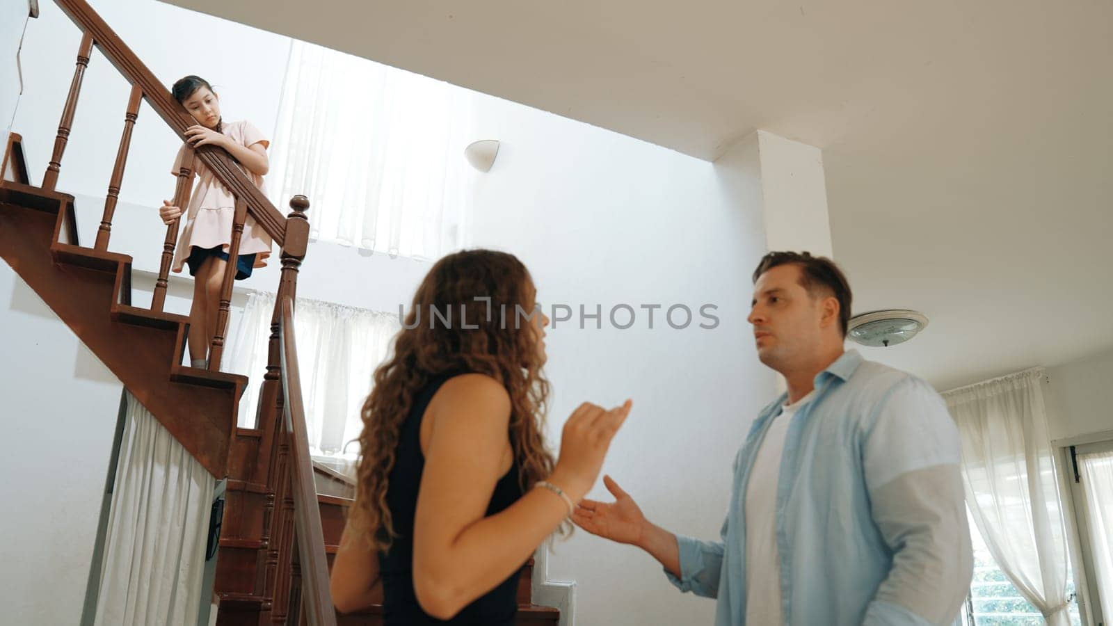 Stressed and unhappy young girl watch her parent arguing from the stair. Domestic violence at home and traumatic childhood develop to depression and anxiety. Unhealthy family concept. Synchronos