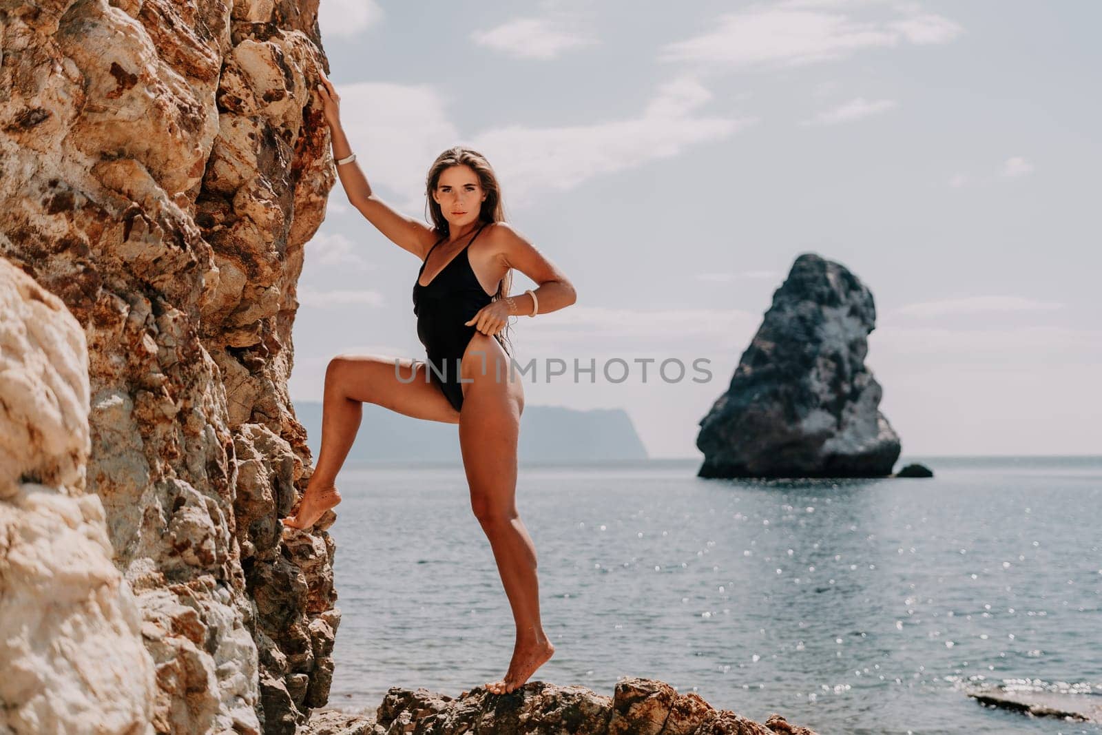 Woman summer travel sea. Happy tourist enjoy taking picture outdoors for memories. Woman traveler posing on the beach at sea surrounded by volcanic mountains, sharing travel adventure journey by panophotograph