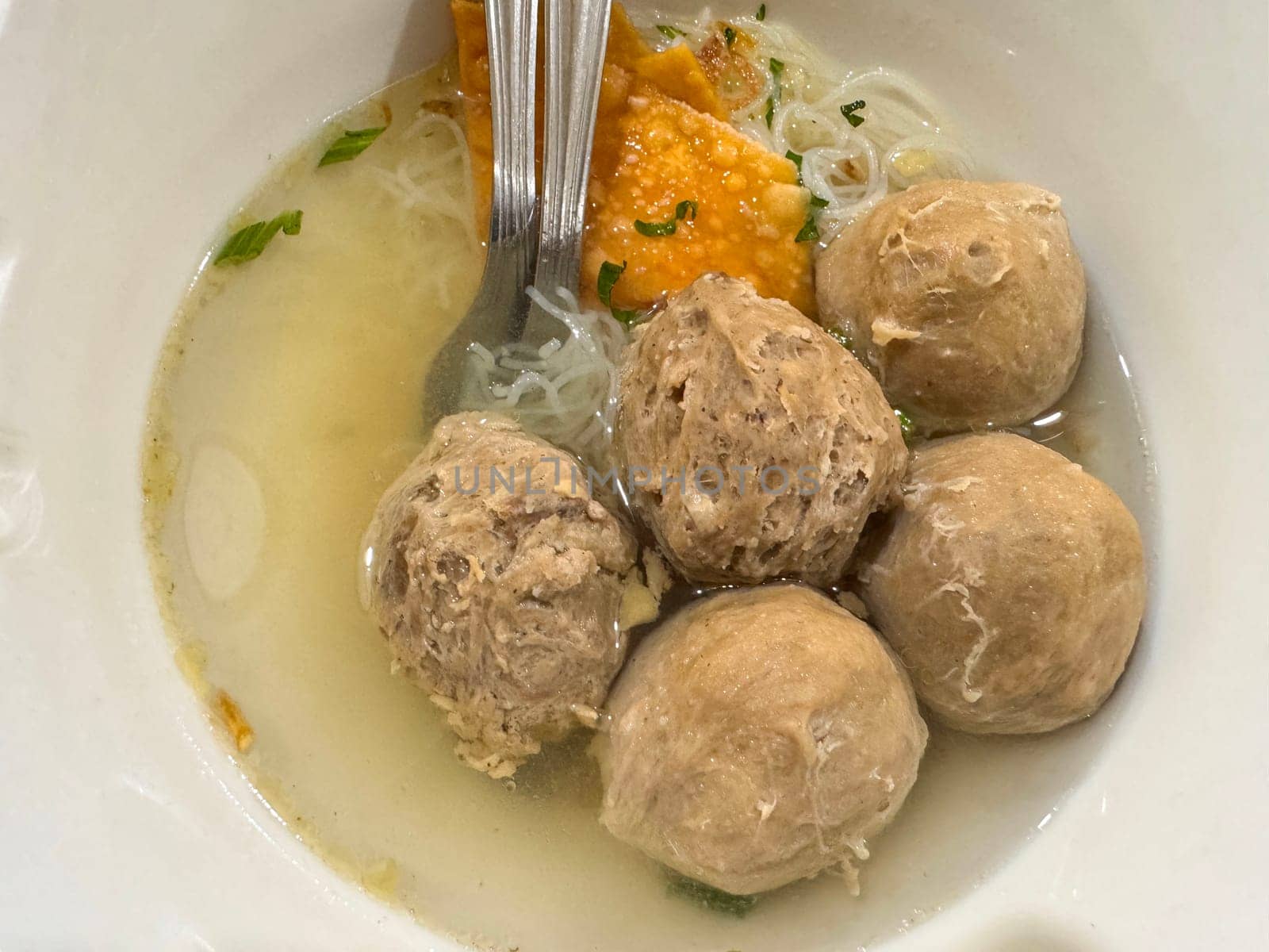 super delicious, tender and juicy and spicy bites of beef tendon meatballs in a bowl in Indonesian street food