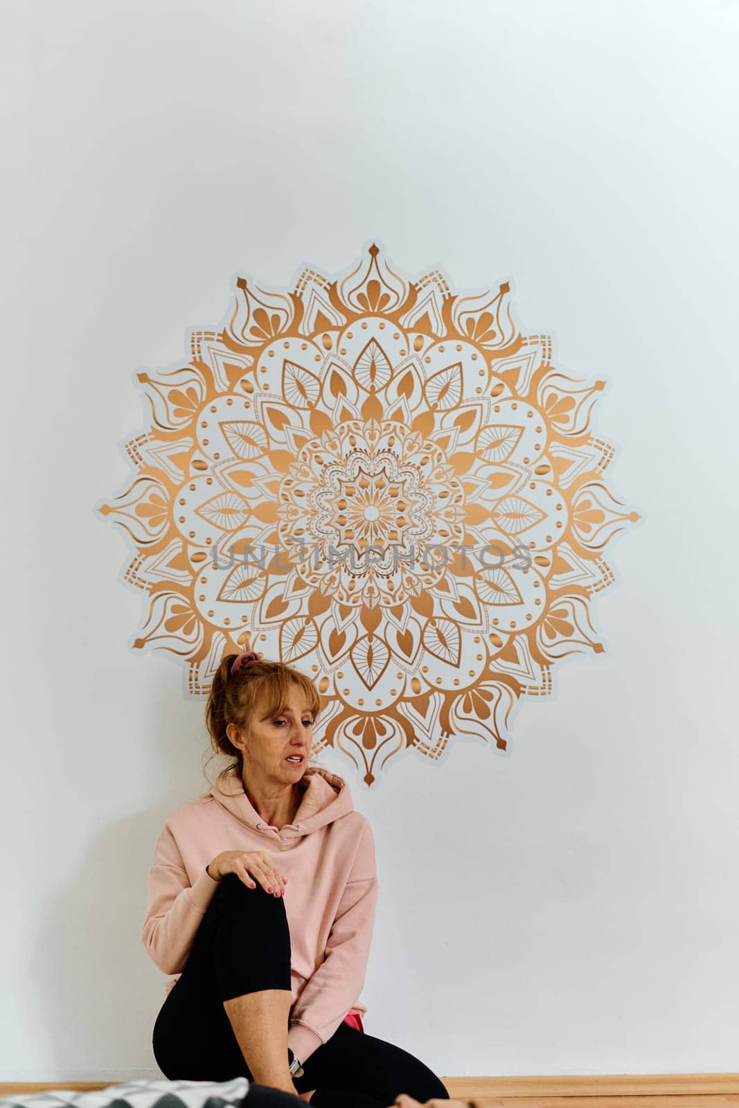 A skilled trainer oversees a group of senior women practicing various yoga exercises, including neck, back, and leg stretches, in a sunlit space, promoting wellness and harmony.