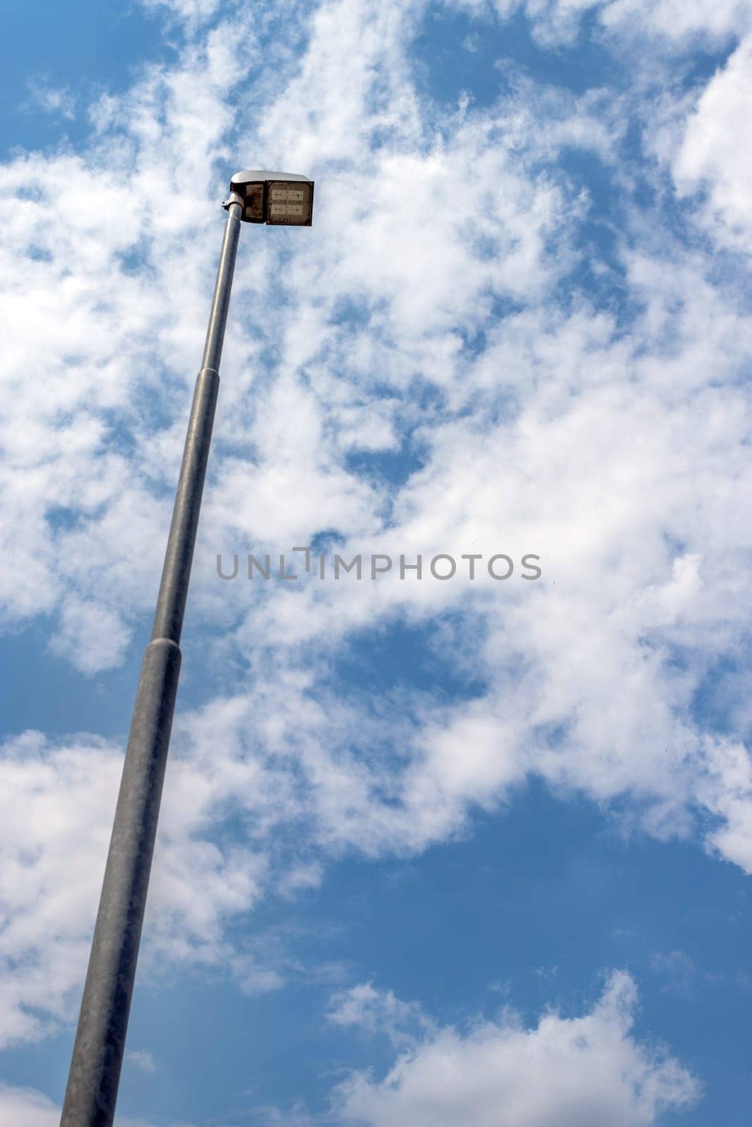 LED street lamp post on blue sky background with white clouds