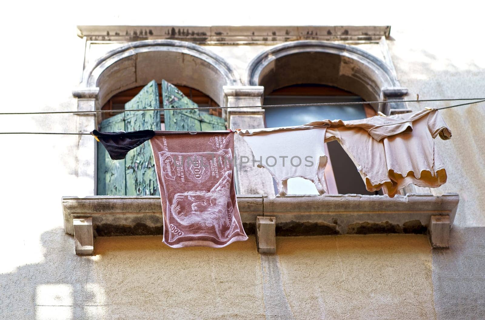 Gorgeous Venice. The narrow street channel. Picturesque laundry drying on clothesline by aprilphoto