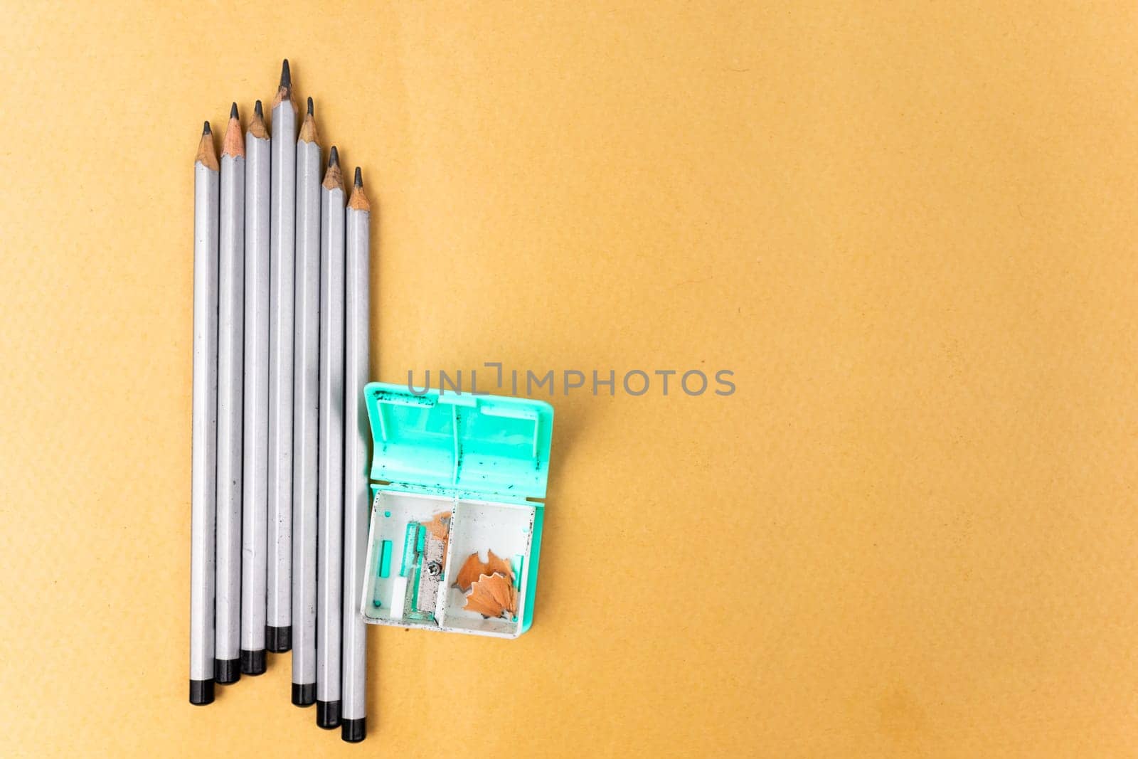 Several pencils and a sharpener on a yellow background. Copy space by Serhii_Voroshchuk
