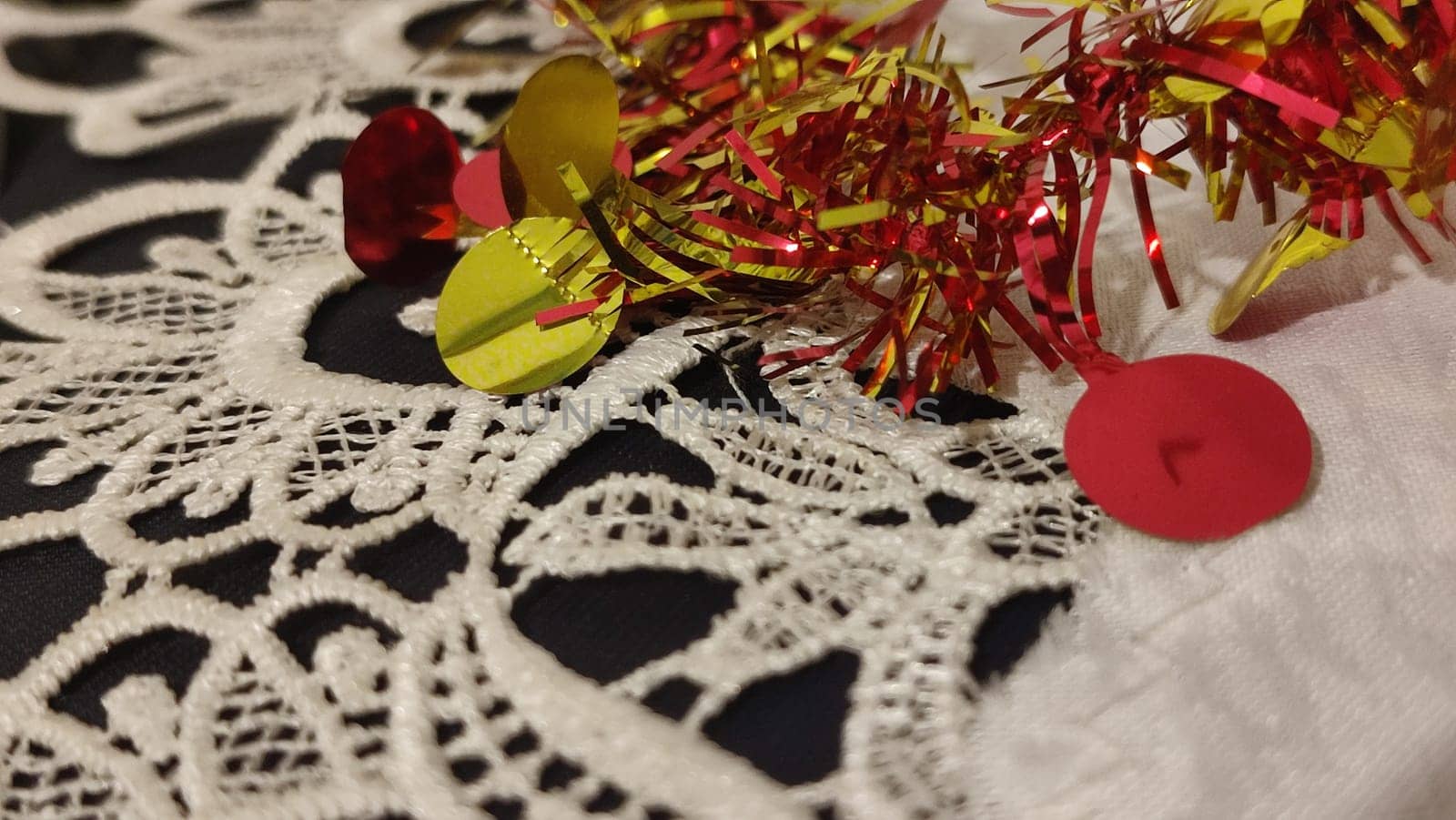 red and yellow Christmas garland, white lace tablecloth. High quality photo
