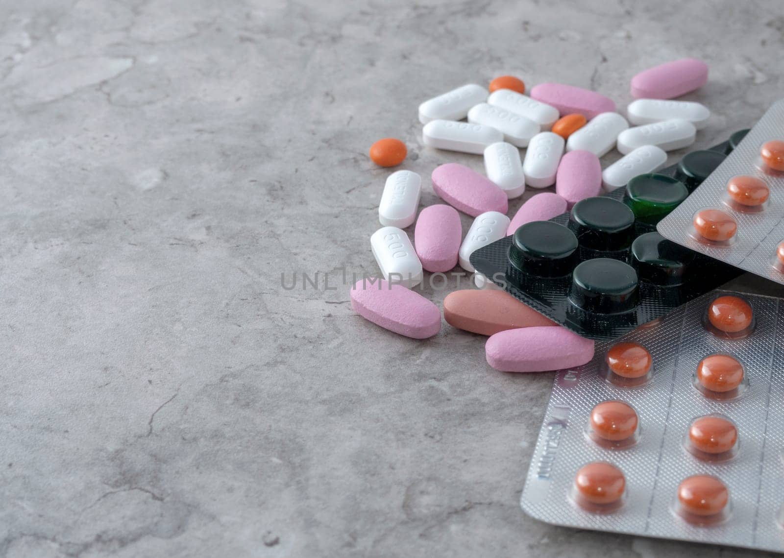 multicolored medical pills and packs of pills on a table.