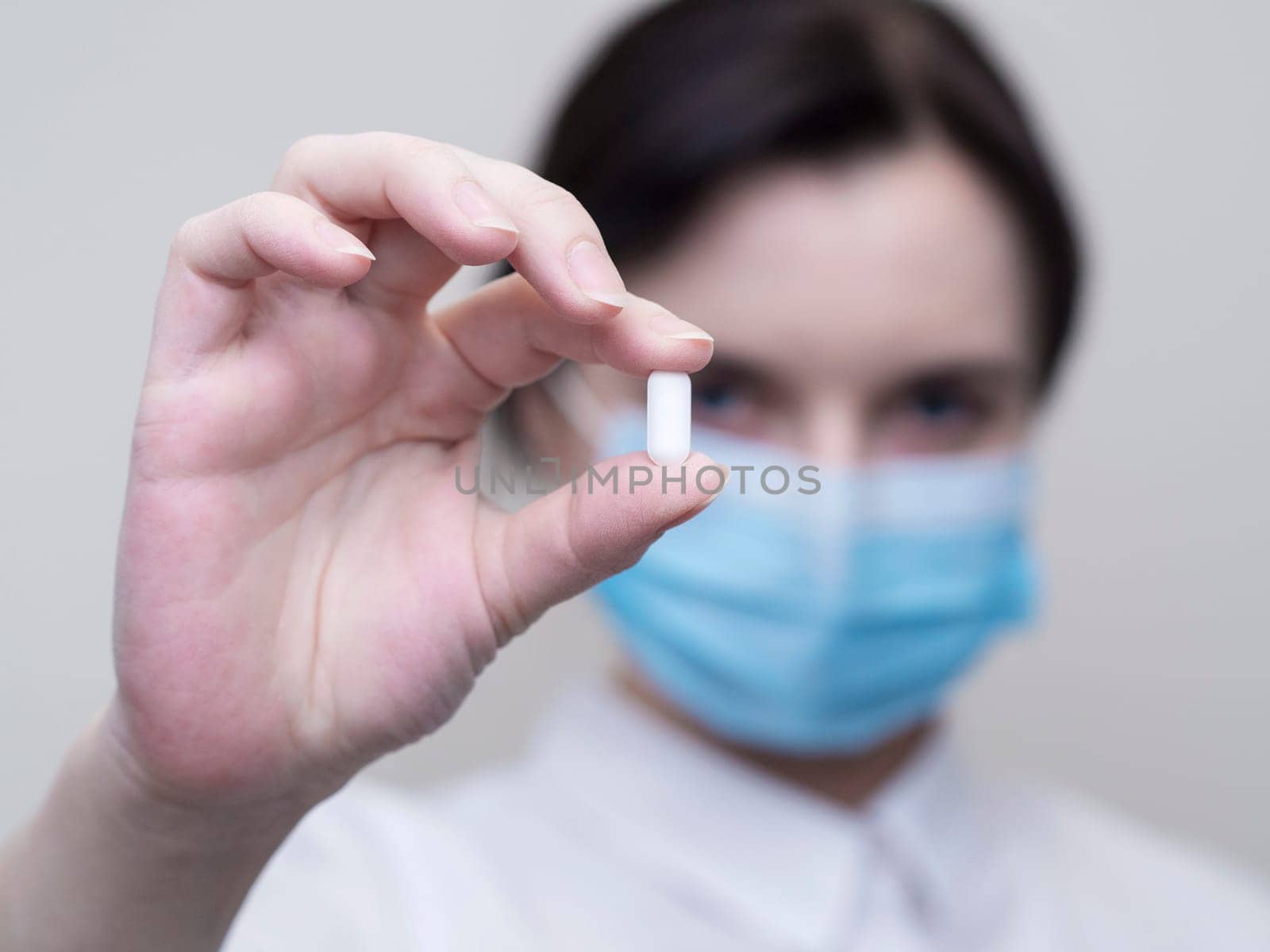 Doctor giving pills, woman in medical mask and gloves. The concept of the dose of drugs, vitamins, medical examination, coronavirus, treatment of influenza