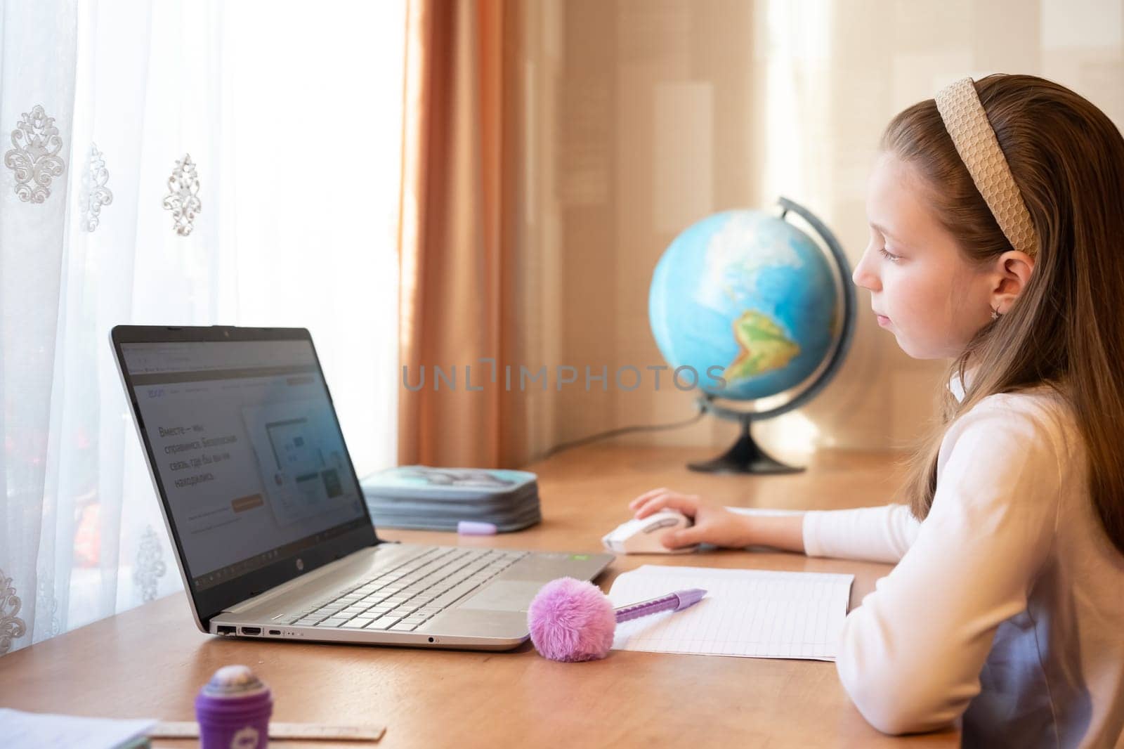 Online education of children. schoolgirl teaches a lesson online using a laptop video chat call conference with a teacher at home.pupil using conferencing on laptop with remote teacher, tutor. by YuliaYaspe1979