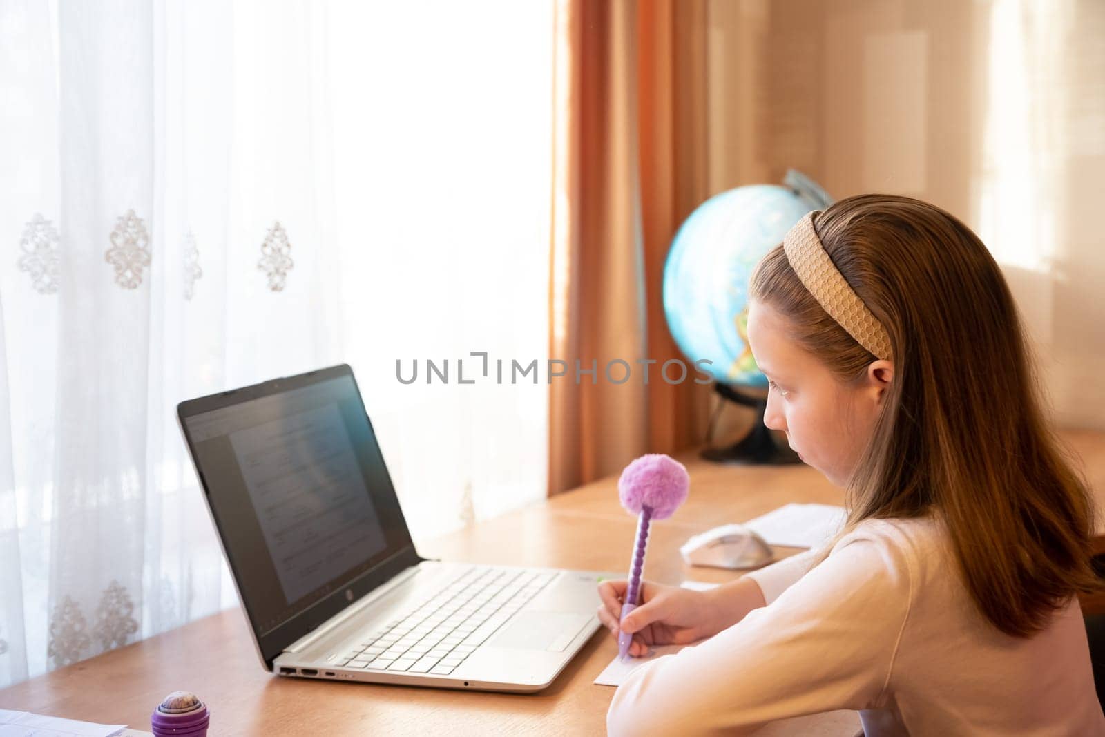 Online education of children. Girl schoolgirl teaches a lesson online using a laptop video chat call conference with a teacher at home.