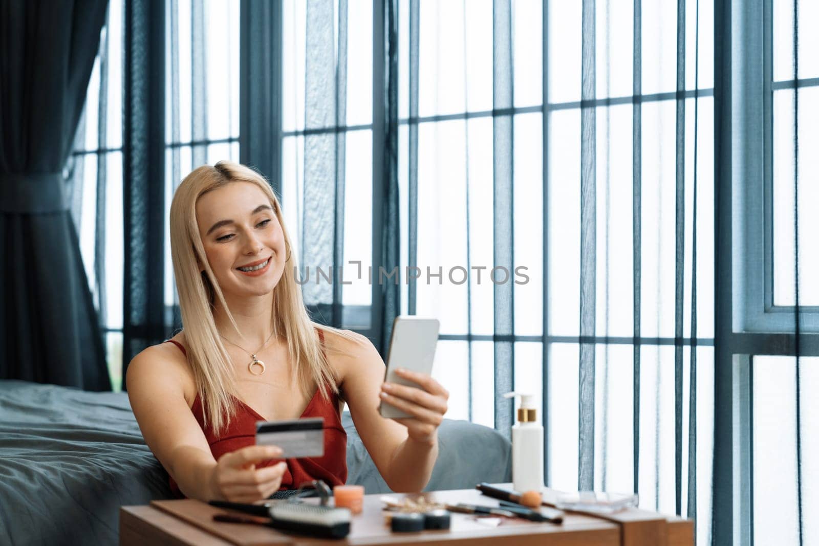 Young woman using online payment app and digital wallet on smartphone to pay with credit card. E commerce shopping and modern purchasing via mobile internet. Blithe