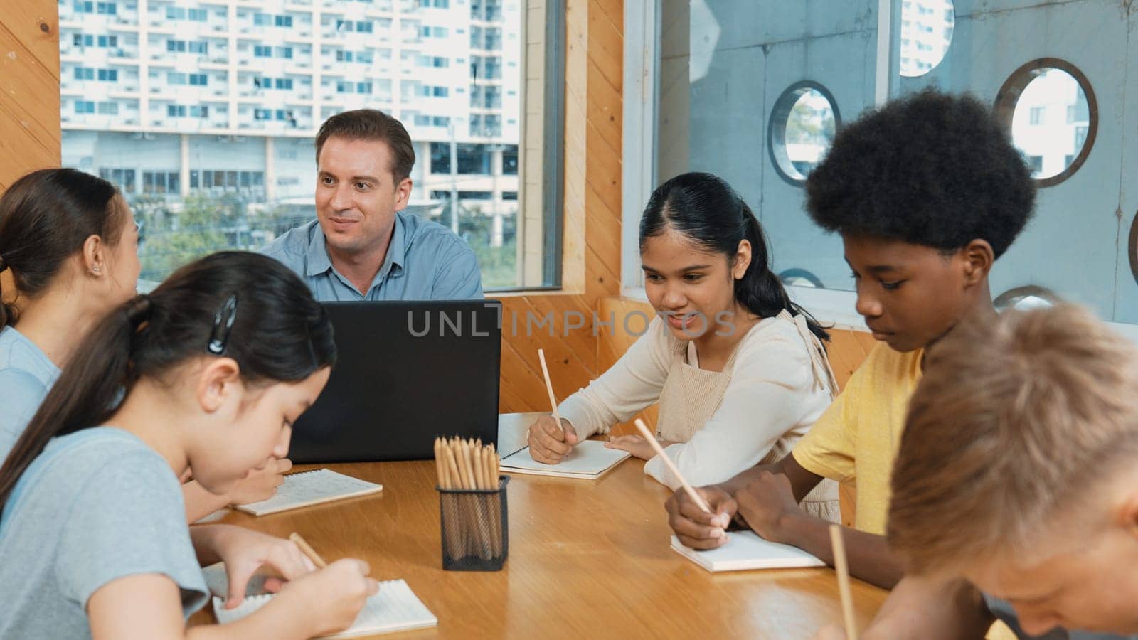 Caucasian teacher and smart boy discuss about project at classroom. Professional instructor talking about classwork while giving a paper to highschool child with diverse student listen. Edification.