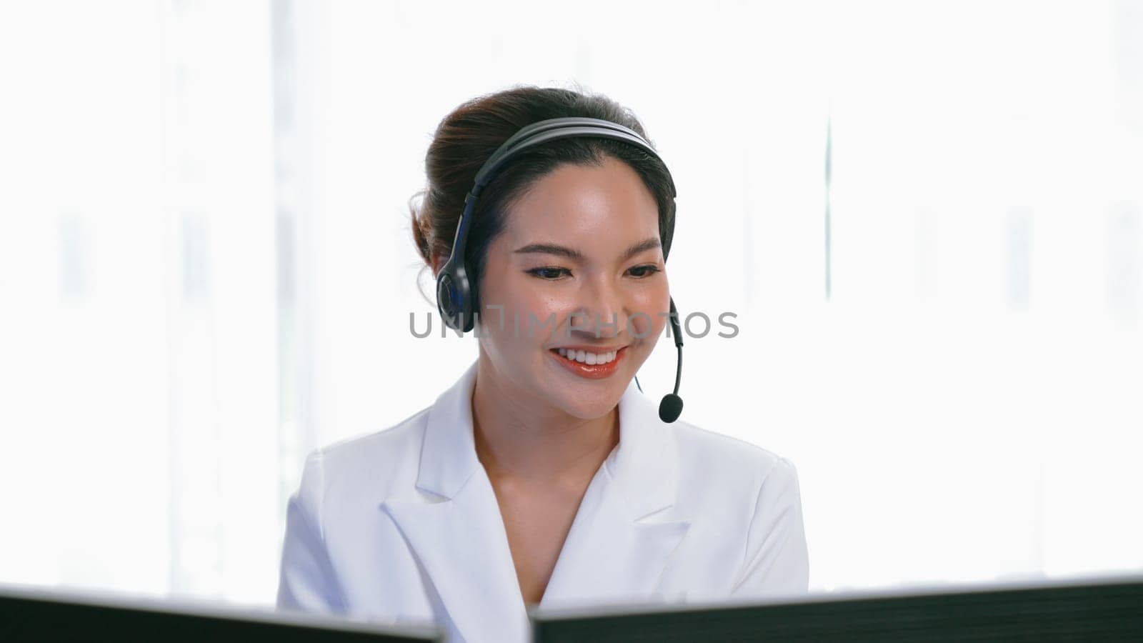 Businesswoman wearing headset working in vivancy office by biancoblue