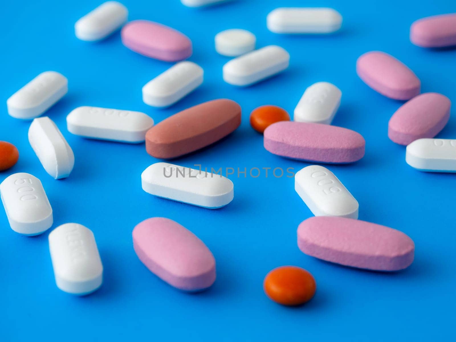 Colored pills on a blue background top view