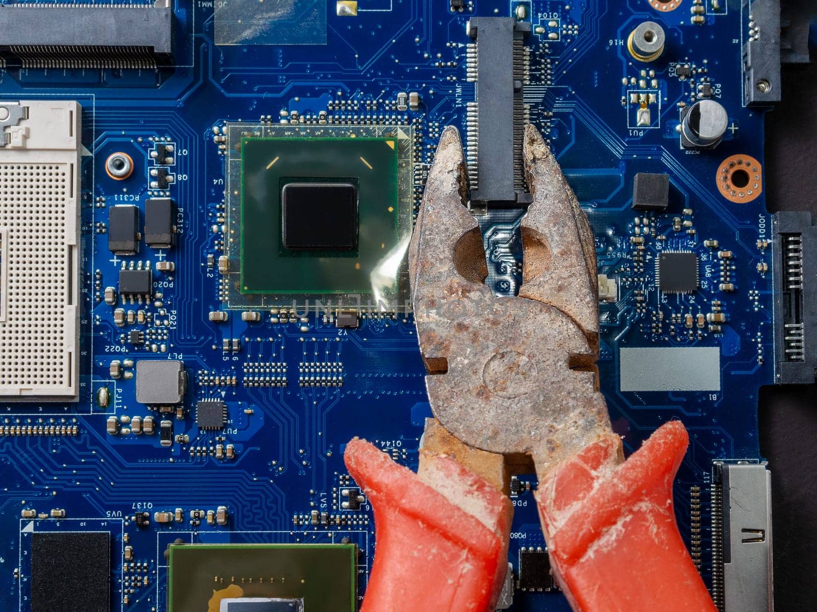 Computer repair concept. Old rusty passages on a blue laptop motherboard. The concept of unskilled work. by Andre1ns