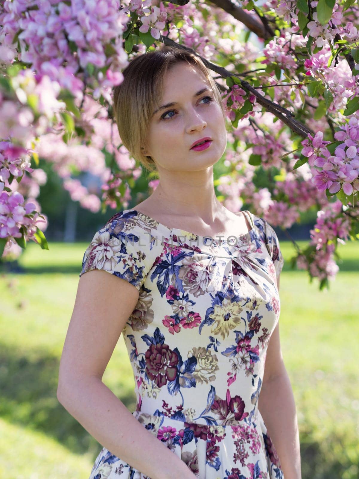 Young beautiful blonde woman in blooming garden. Bride.