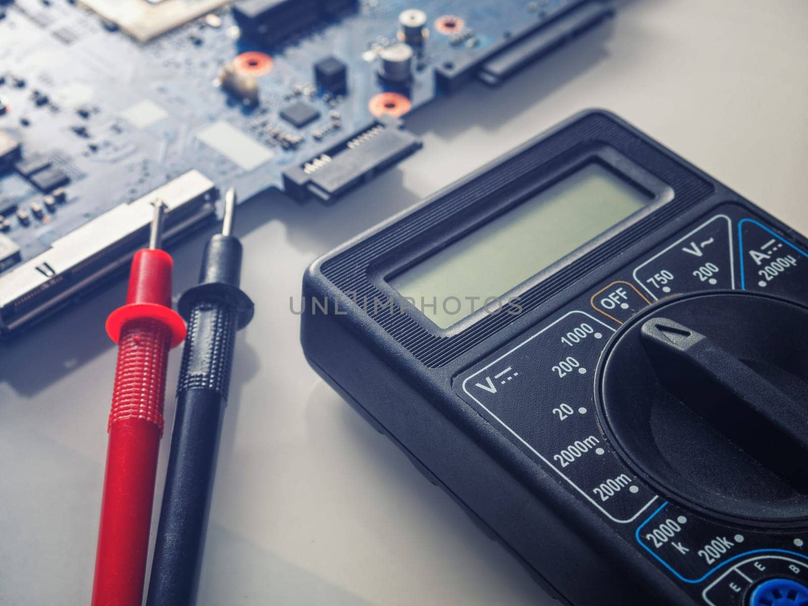 Multimeter test, electronic board of digital device with components. Troubleshoot electronic device. Computer and mobile device repair concept
