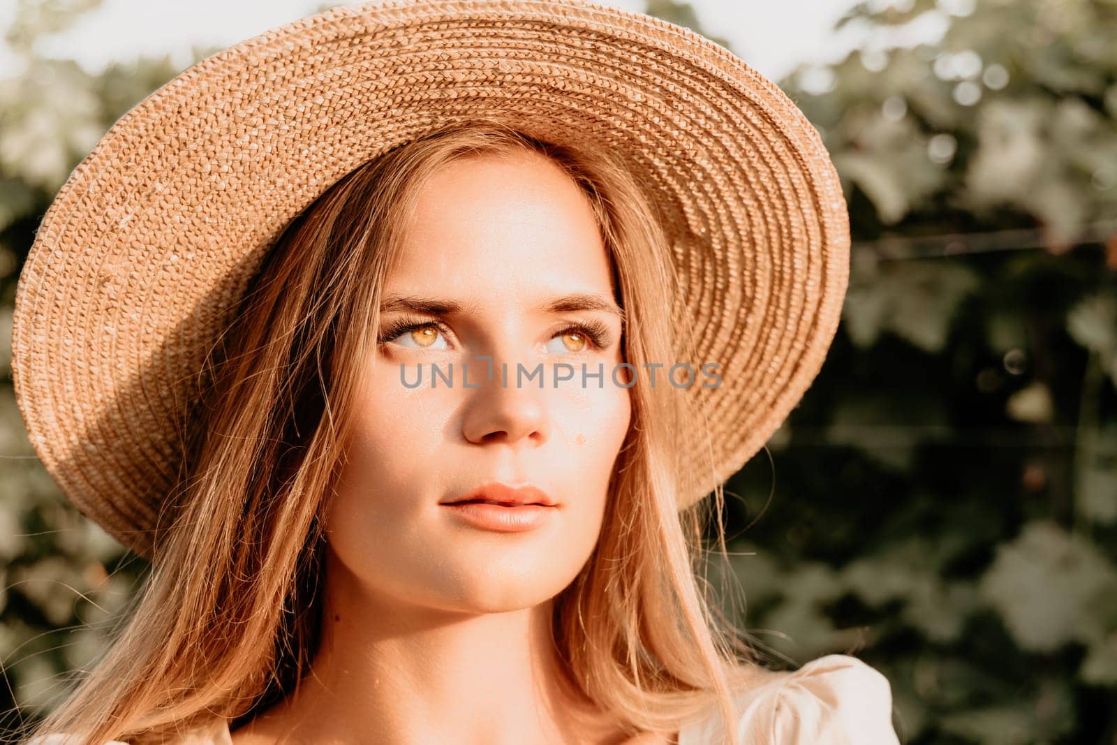 Woman at autumn winery. Portrait of happy woman holding glass of wine and enjoying in vineyard. Elegant young lady in hat toasting with wineglass smiling cheerfully enjoying her stay at vineyard. by panophotograph