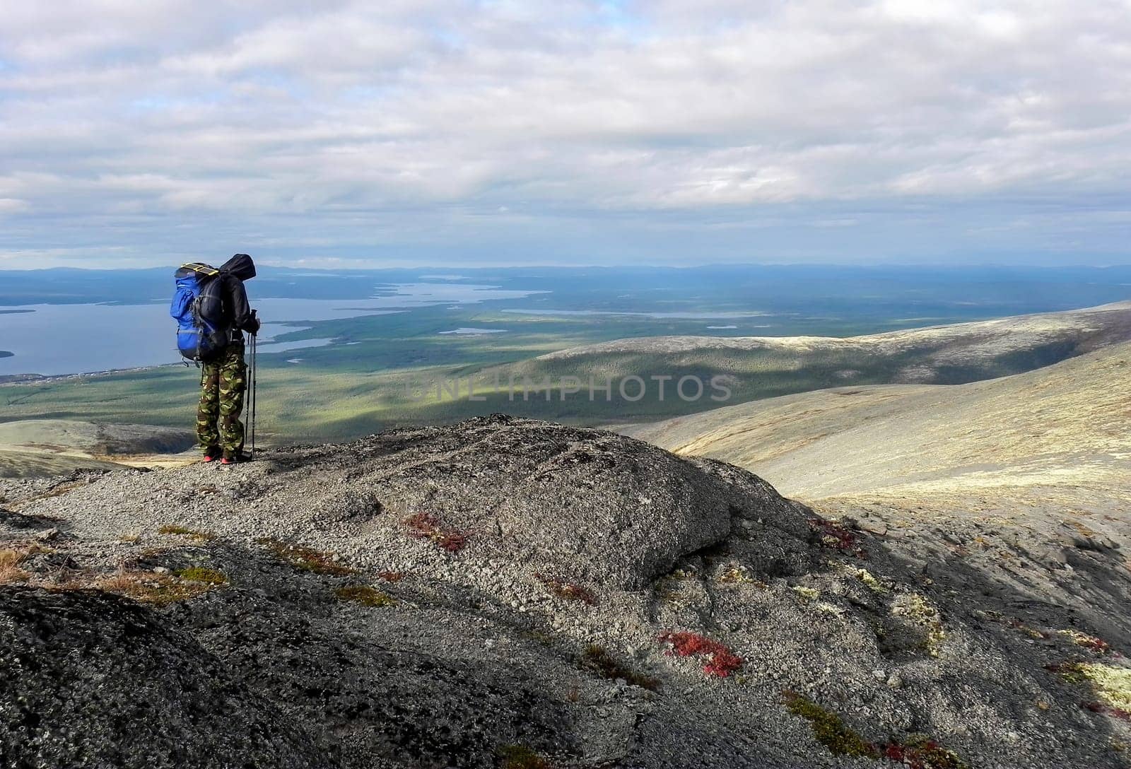 Man on the top of the mountain. Hiker with a backpack on the mountain. Conceptual design.