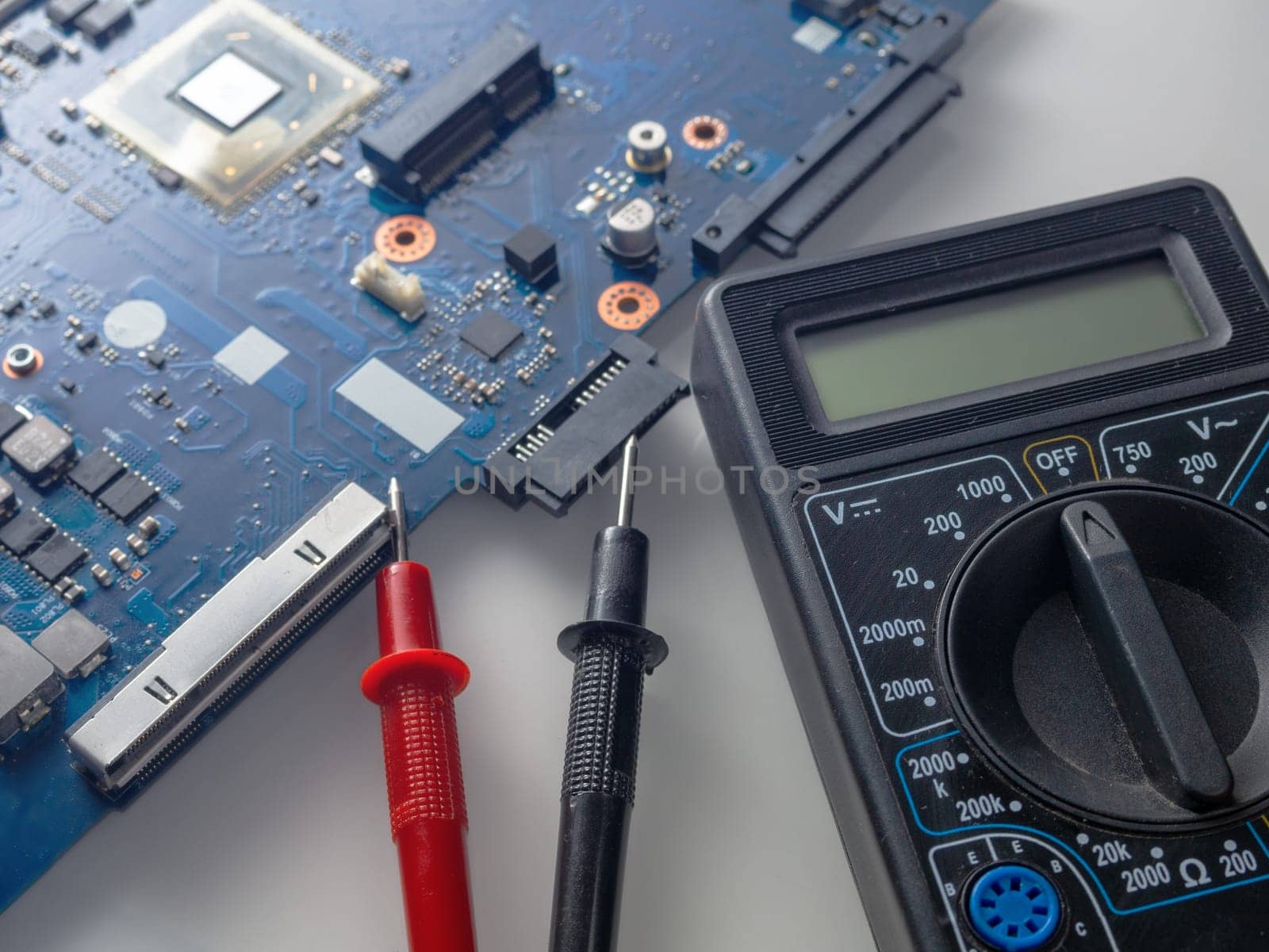 Multimeter test, electronic board of digital device with components. Troubleshoot electronic device. Computer and mobile device repair concept