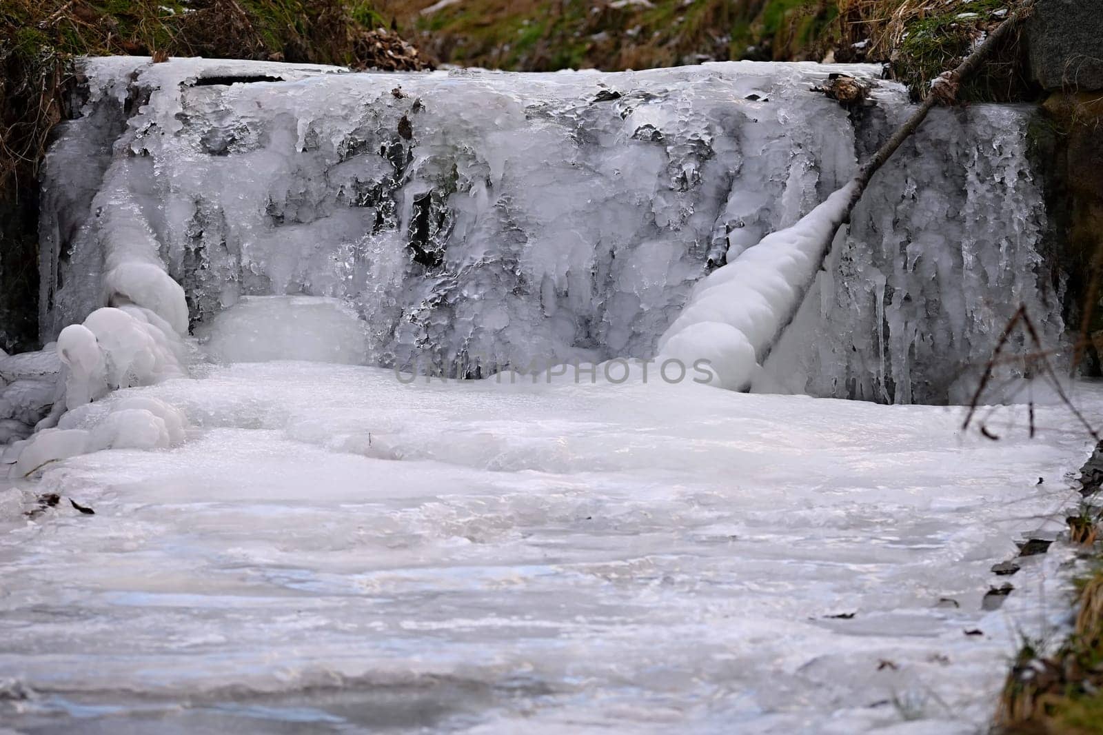 Frozen stream. Beautiful winter nature background. Frost, ice and snow in the winter. by Montypeter