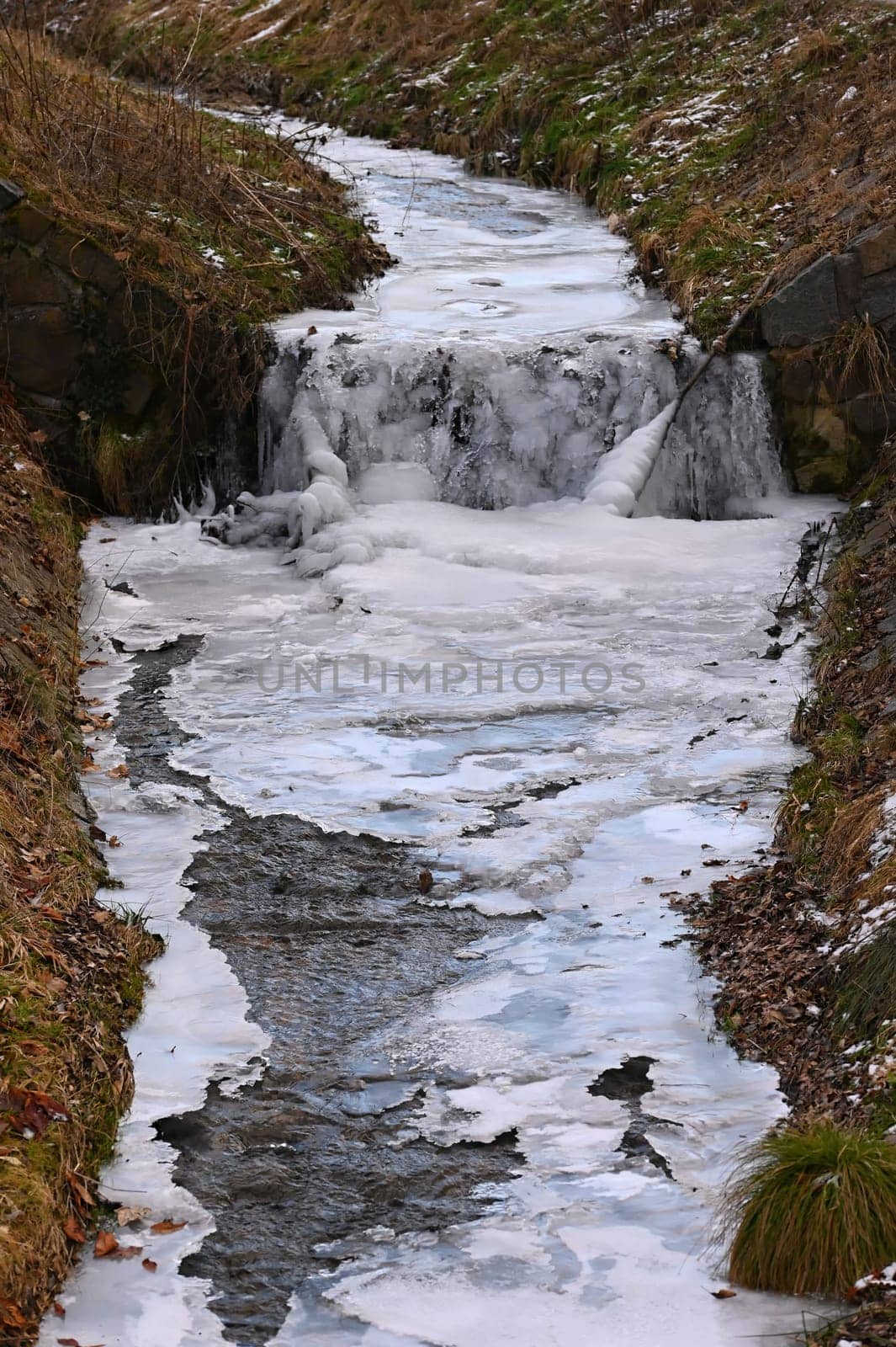 Frozen stream. Beautiful winter nature background. Frost, ice and snow in the winter. by Montypeter