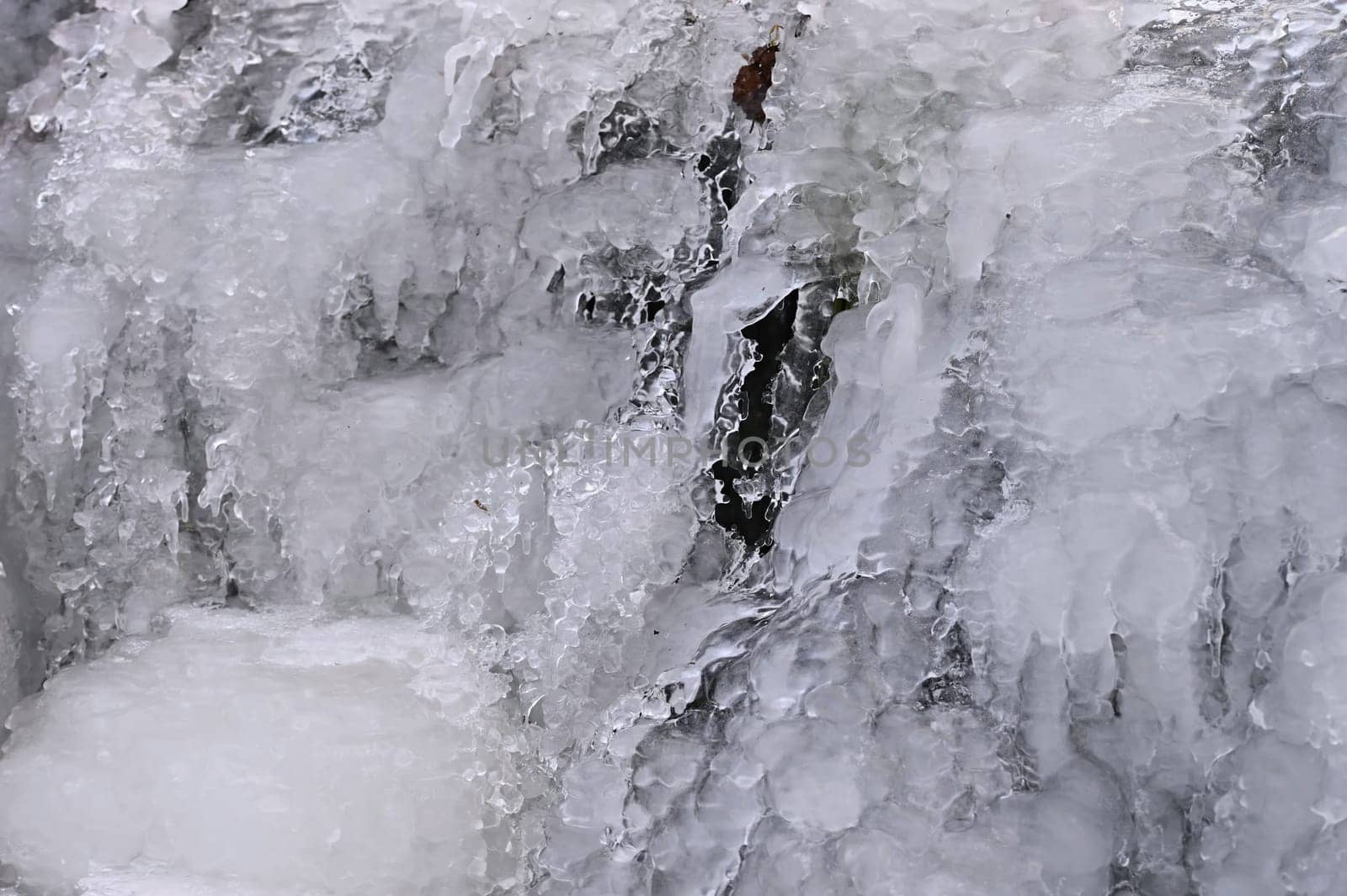 Frozen stream. Beautiful winter nature background. Frost, ice and snow in the winter.