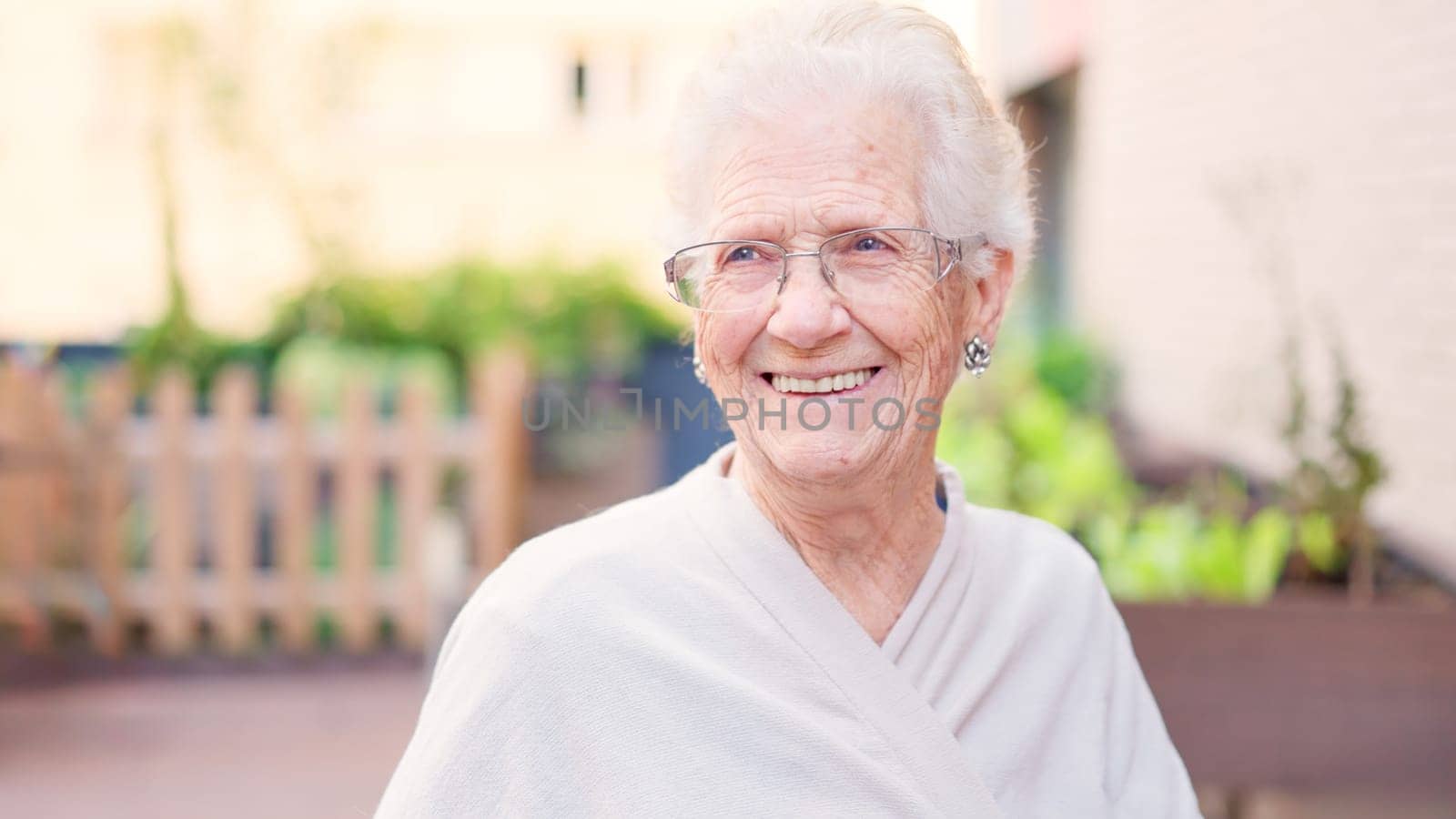 Old woman smiling looking to the copy space in a urban garden