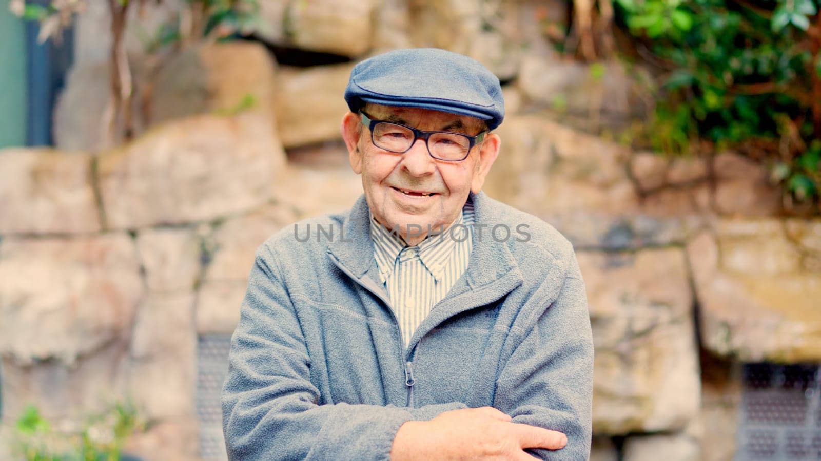 Proud grandfather crossing arms and looking at camera outdoors in a nursing home