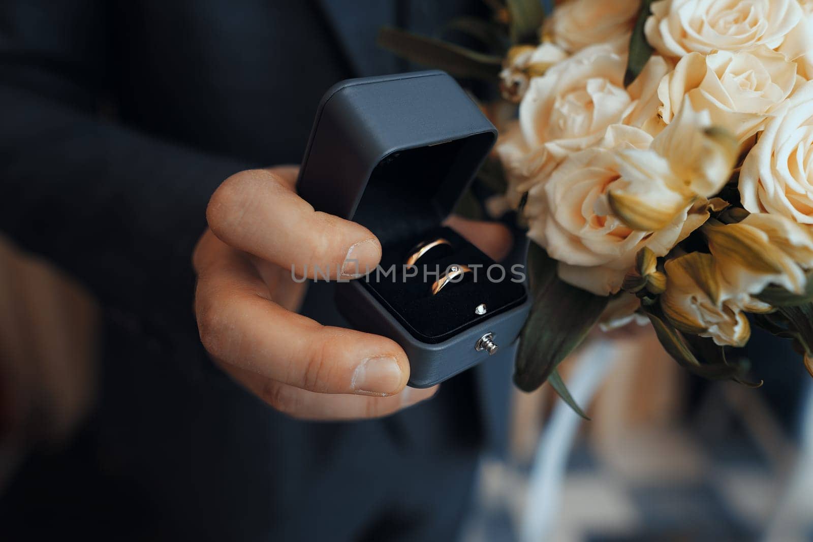 wedding rings lie on a beautiful bouquet as bridal accessories by krol666