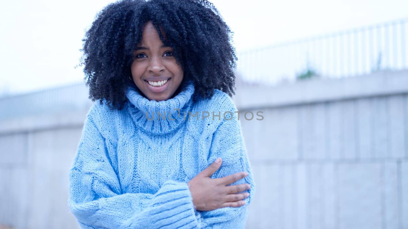 Young african woman gesturing cold in the street