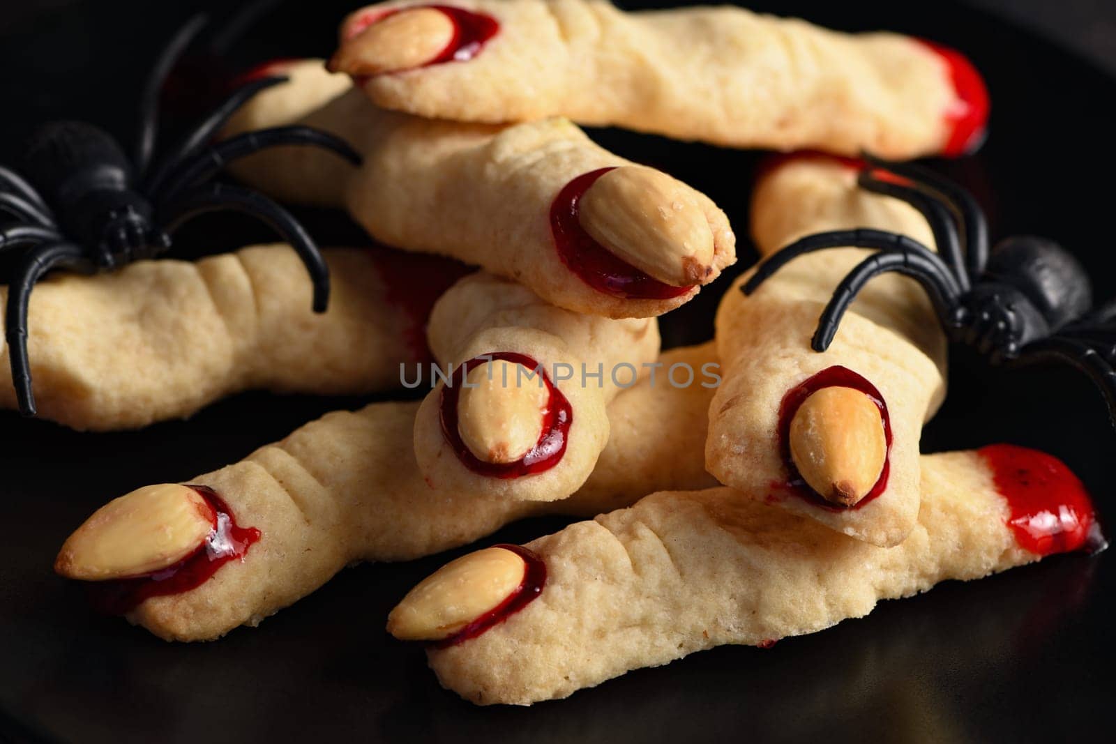 Creepy, scary Witch fingers made from sugar cookies with raspberry jam and almonds on Halloween. Trick-or-treat. Classic Cookie Witch Fingers takes on a healthy, gluten-free, paleo, vegan look.