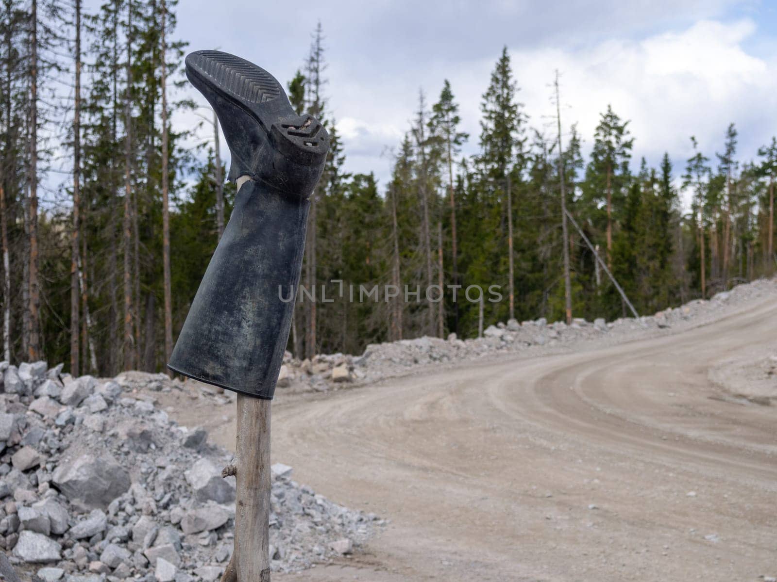 Rubber boot on a stick, bad road signpost.
