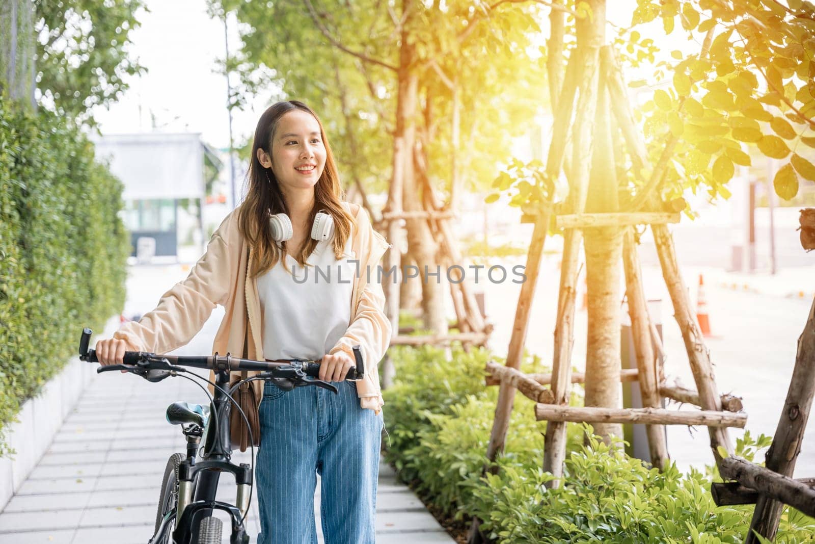 Lifestyle Asian young woman walking alongside with bicycle on summer in countryside outdoor by Sorapop