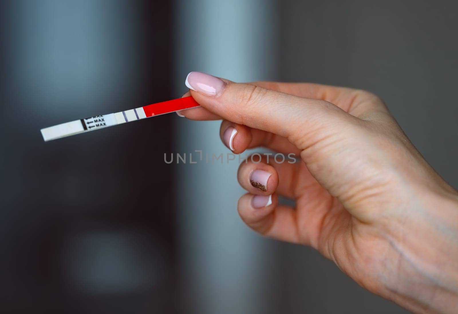 Woman hand holding positive pregnancy test with two lines on it. Pregnancy or fertility concept. High quality photo. High quality photo