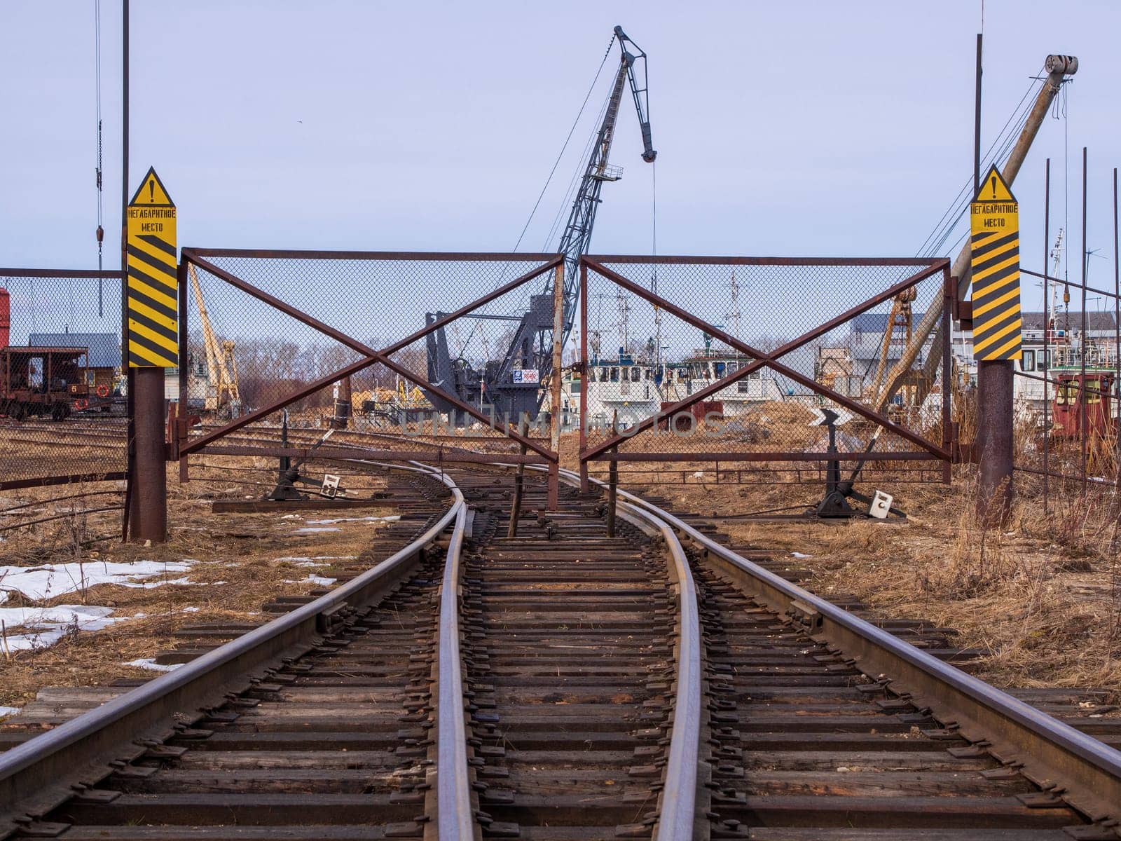 Rail road tracks under the gantry cranes on the berth of sea merchant port by Andre1ns