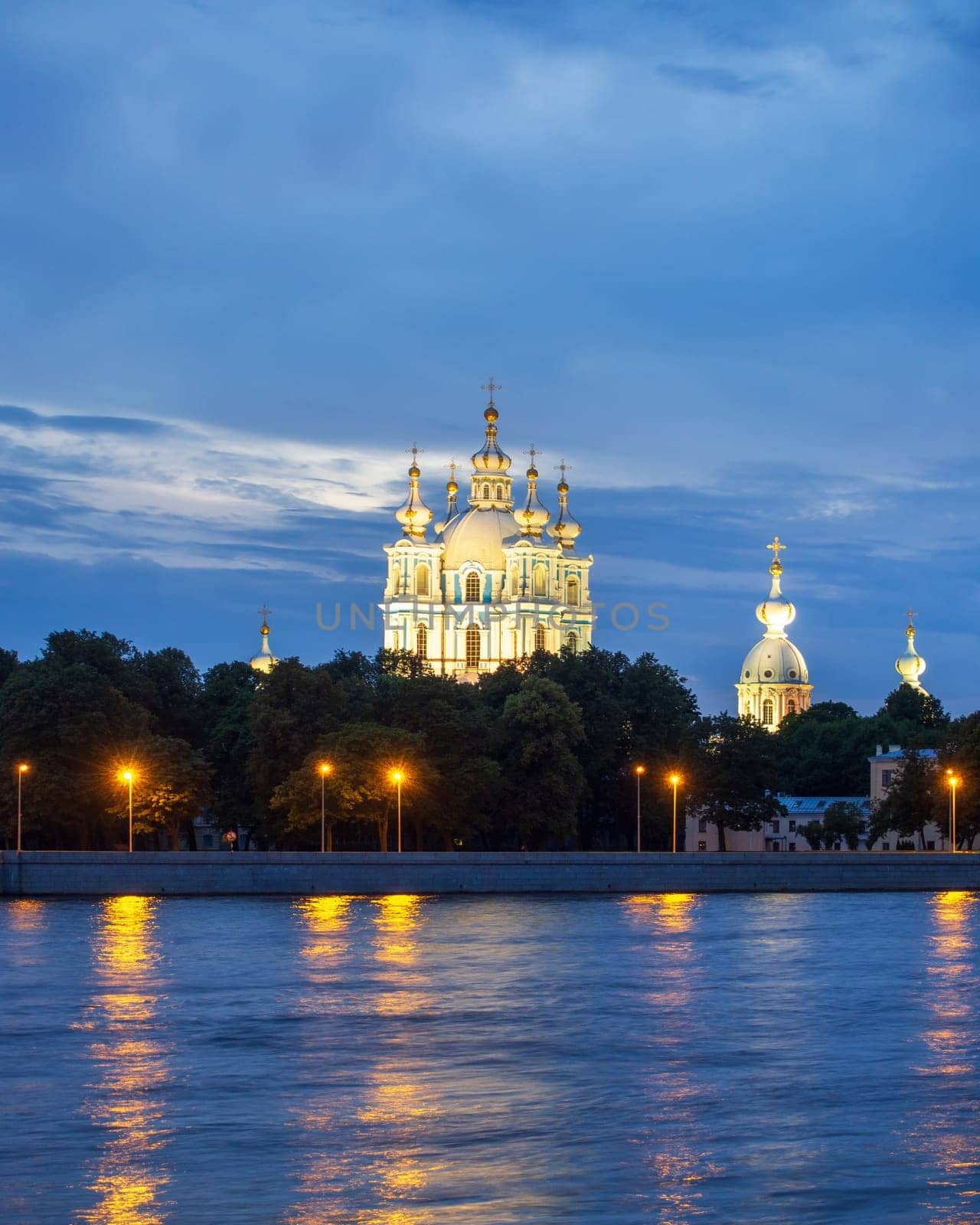 View of the Smolny Cathedral from the Neva at night on a cloudy summer day. Russia, Saint-Petersburg
