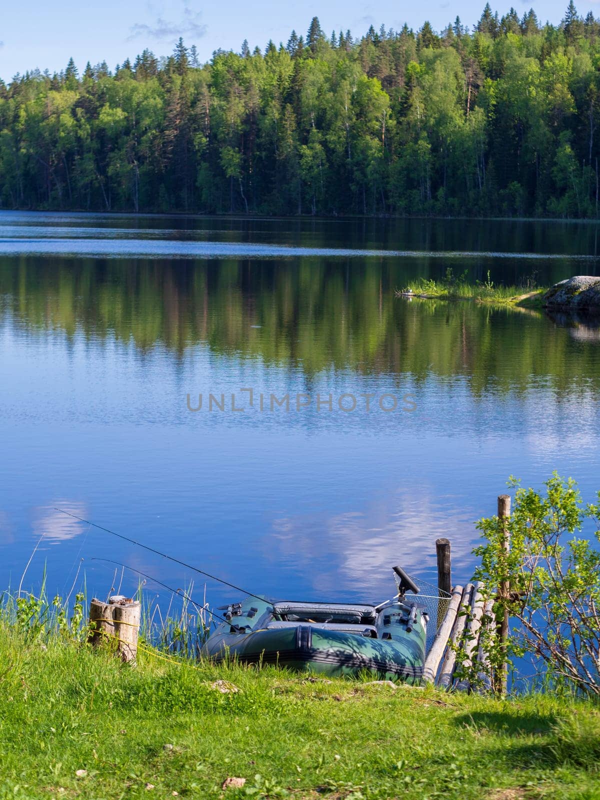 Inflatable boat with fishing rods on the lake