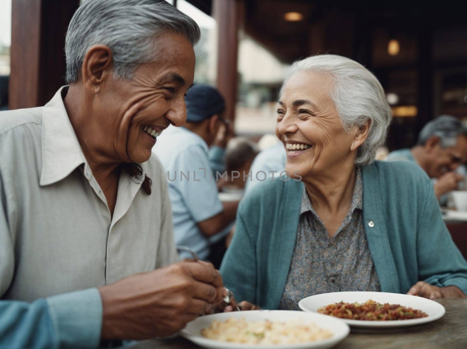 A couple enjoying a meal together as they sit at a table with delicious plates of food.