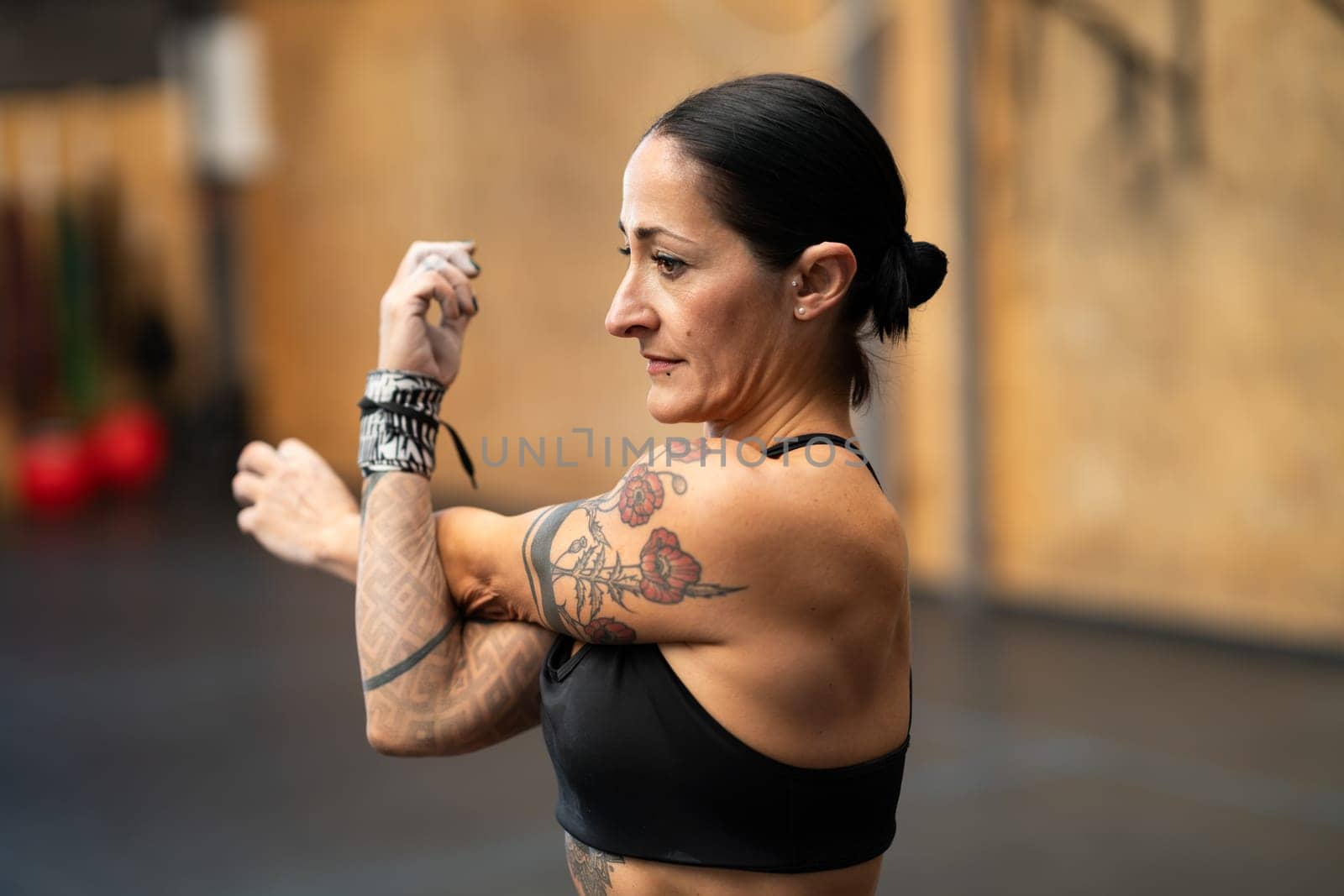 Close-up of a strong athletic woman stretching arms before train in a gym