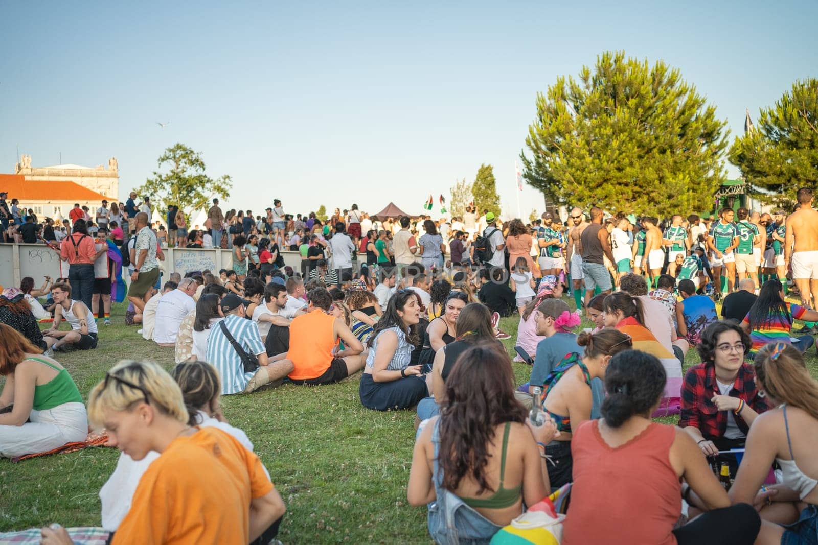 Lisbon, Portugal. 17 June 2023 People relaxing and having fun in park during Pride Parade. Happy free people sitting on lawn, communicating and playing ball at lgbtqia pride event in park Lisbon