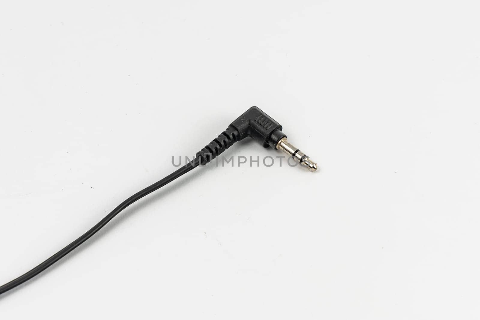 Long black cable of headphones with microjack connector at the end by Wierzchu