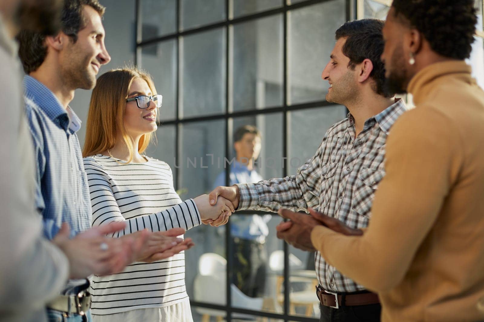 Multiethnic business people shaking hands in office lobby by Prosto