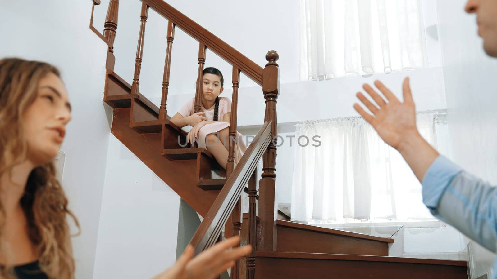 Unhappy young girl watch her parent arguing from the stair. Synchronos by biancoblue