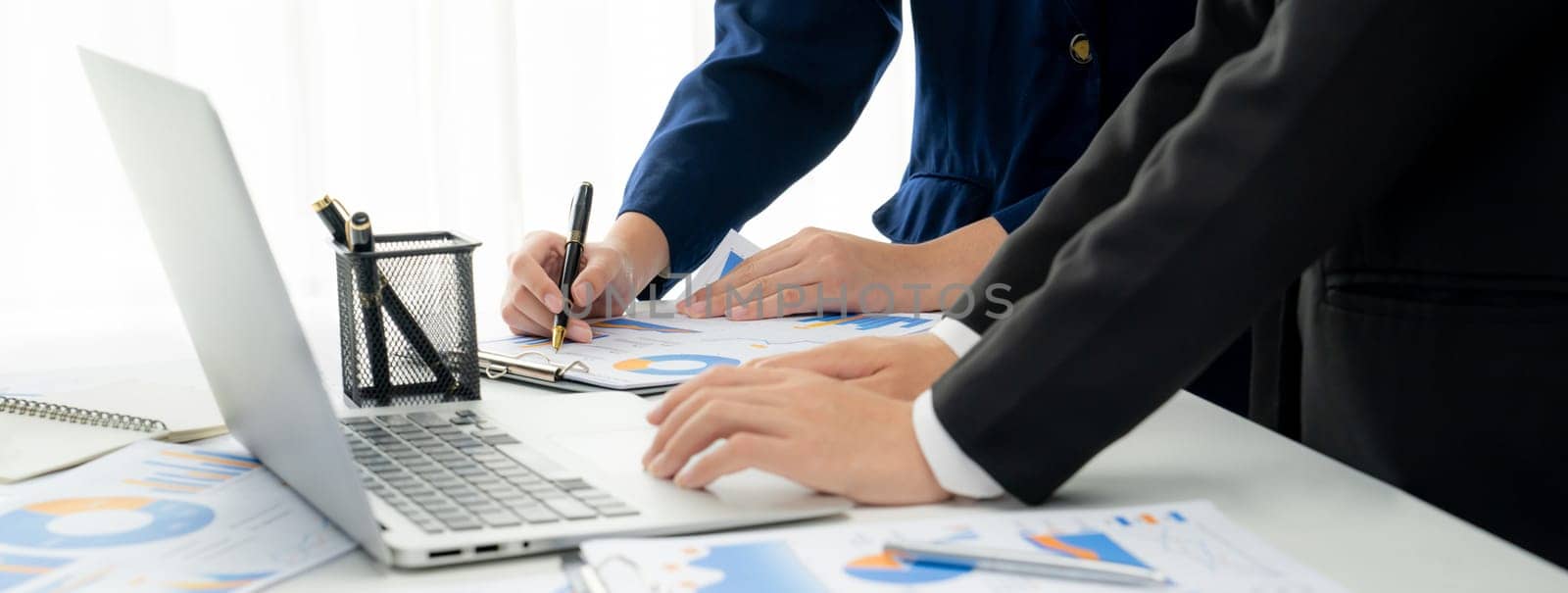 Business people in group meeting in formal attire share idea discussing report for company profit in creative workspace for start up business shot in close up view on group meeting table . Oratory .