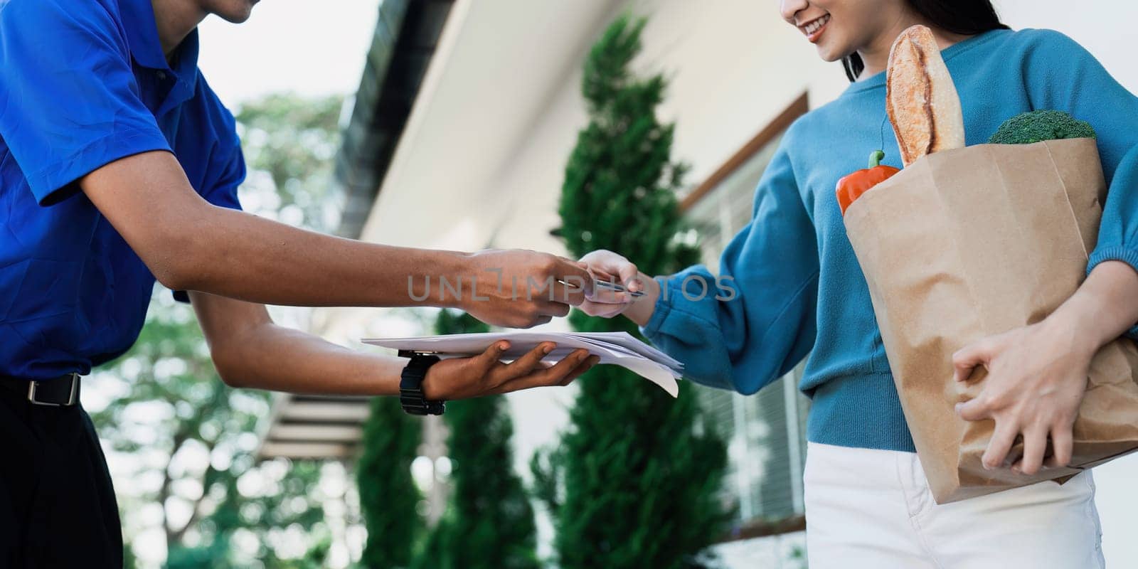 Asian young delivery man delivering package to female customer at home by itchaznong