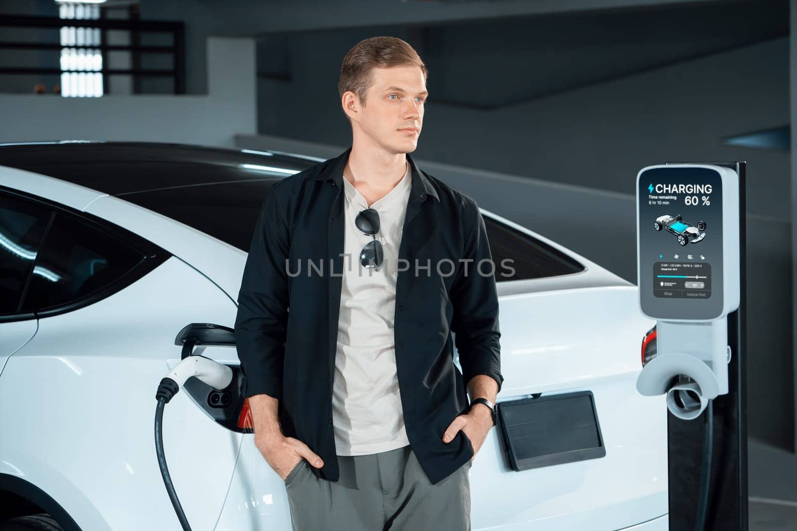 Young man travel with EV electric car to shopping center parking lot innards by biancoblue