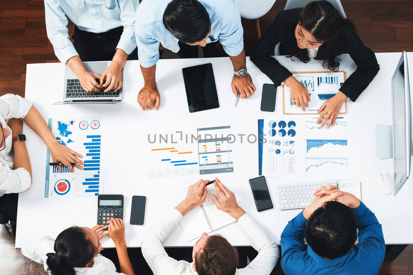 Top view project manager communicate and collaborate with team using project management software, tracking progress of project task and making schedule plan at meeting table. Prudent