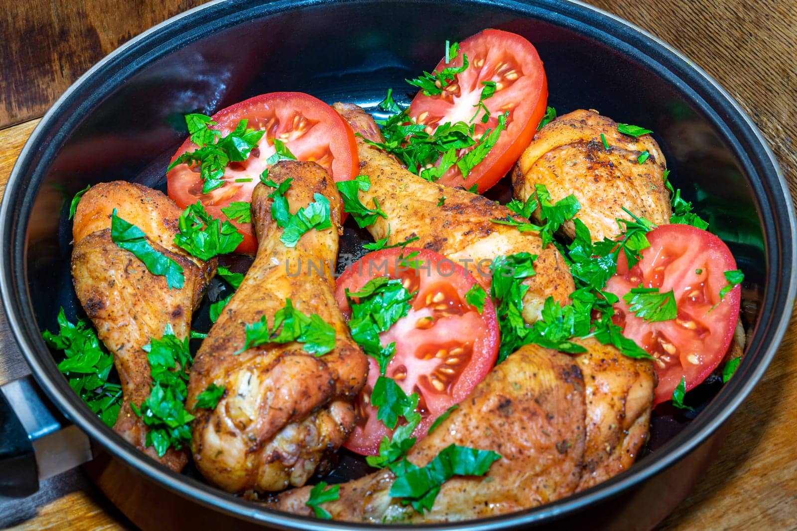 Baked chicken legs with tomatoes and herbs in a pan by Serhii_Voroshchuk