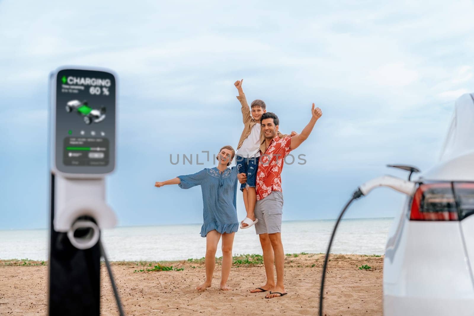 Family vacation trip traveling by the beach with eco-friendly electric car, lovely and cheerful family charging EV car battery on the seascape with green and sustainable energy. Perpetual